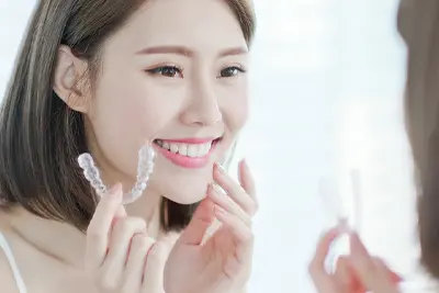 マウスピース矯正のアライナーを取り出す女性